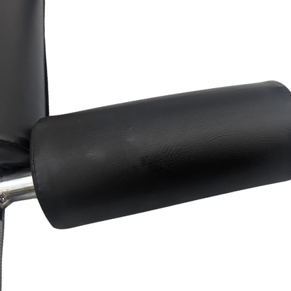 Black padded shoulder pad on silver metal safety squat bar with textured grip surface.