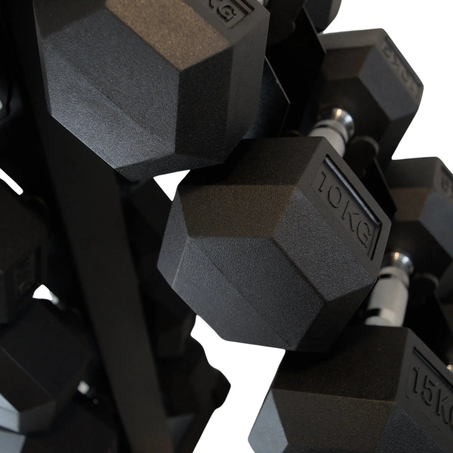 Black rubber hex dumbbells with silver handles neatly stored on a vertical metal rack.