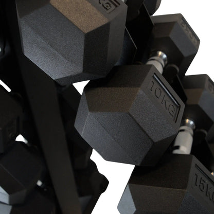 Black rubber hex dumbbells with silver handles neatly stored on a vertical metal rack.